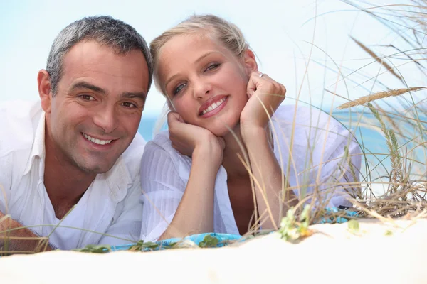 Paar opleggen aan een strand — Stockfoto