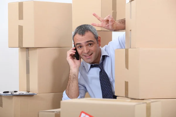 Hombre rodeado de cajas de cartón — Foto de Stock