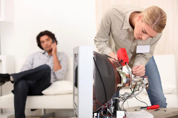 Kvinnliga tekniker reparera en TV — Stockfoto