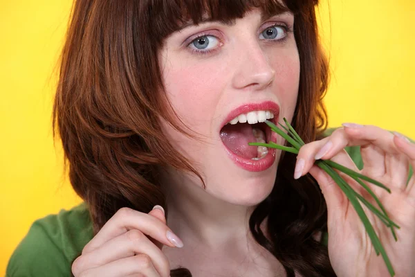 Γυναίκα τρώει σχοινόπρασο — Φωτογραφία Αρχείου