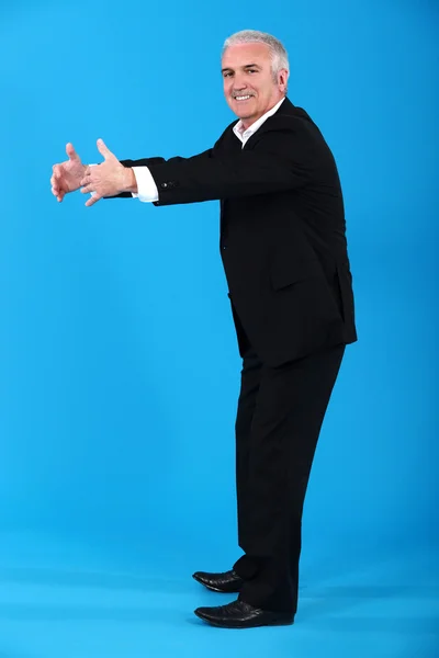青色の背景に立っている陽気なシニア男性 — ストック写真