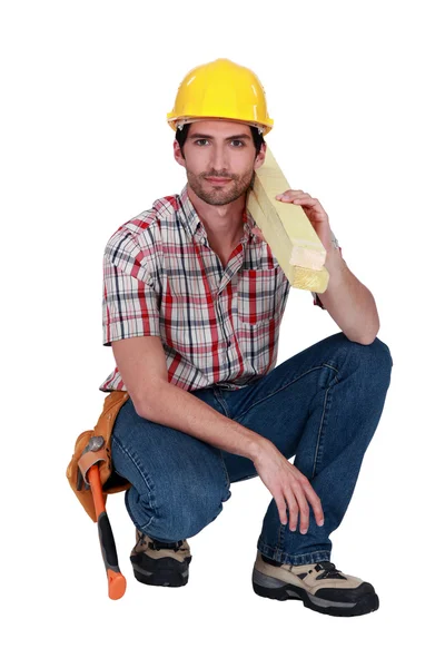 Um carpinteiro masculino ajoelhado . — Fotografia de Stock