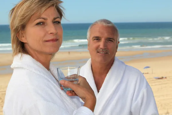 Bornoz bir plajda couple — Stok fotoğraf