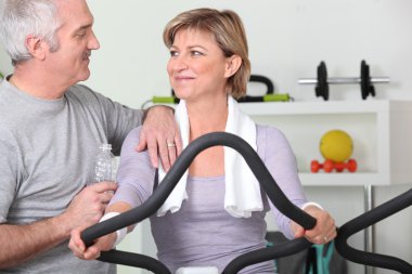 Older couple working out in a gym clipart