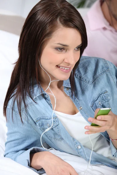 Jovem mulher ouvindo música com mp3 player — Fotografia de Stock
