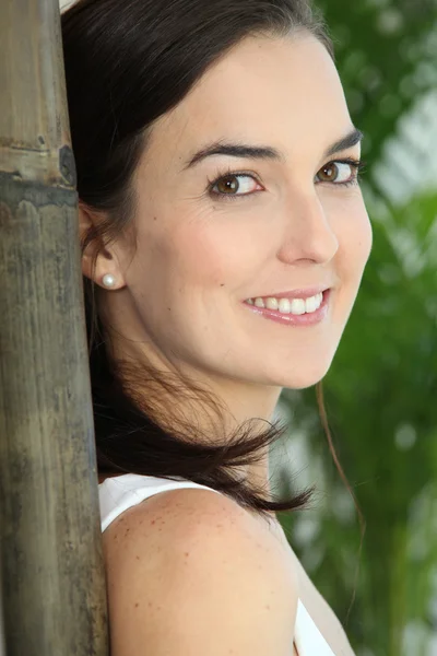 Close up van een vrouw gezicht naast een grote bamboe — Stockfoto