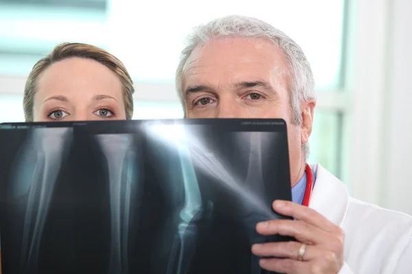 Médico e enfermeira olhando para raio-x — Fotografia de Stock