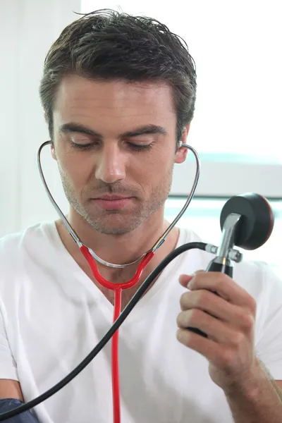 Mann nimmt Blutdruck — Stockfoto