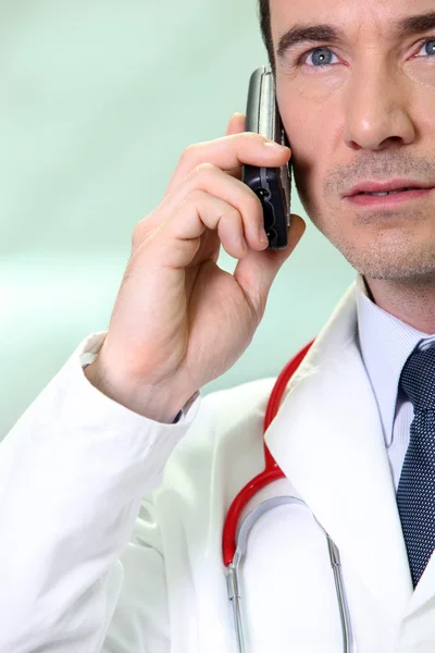 Серьезный врач с помощью мобильного телефона — стоковое фото