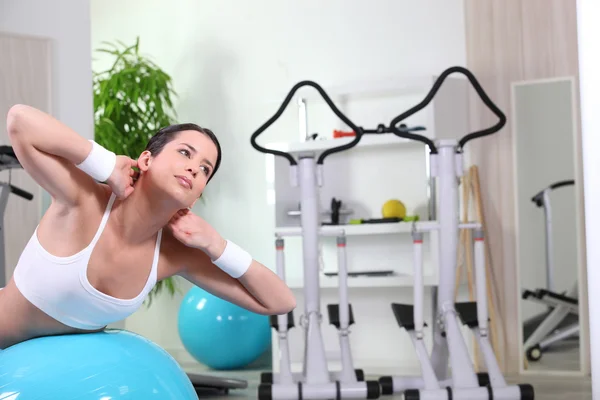 Молодая женщина делает упражнения на животе в тренажерном зале — стоковое фото