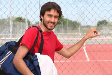 Tennis player stood by outdoor court clipart