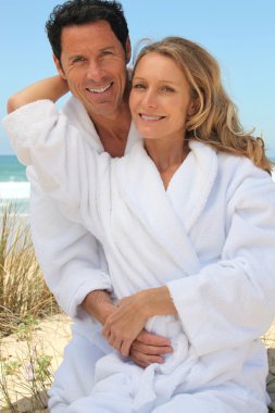 Portrait of couple on dunes in towelling robes clipart