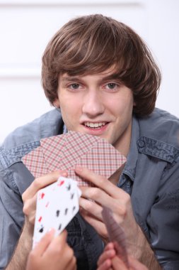 Teenage boy playing cards clipart