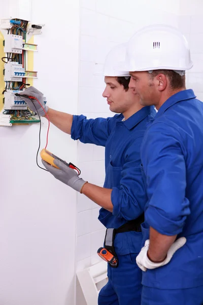 Dvě elektrikáři provádí kontroly — Stock fotografie