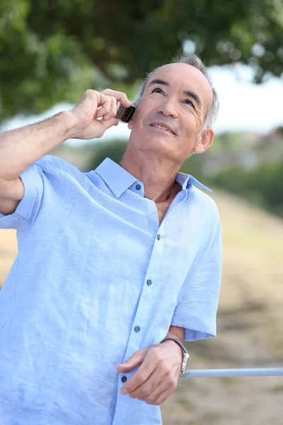 Middelbare leeftijd man buiten met mobiele telefoon — Stockfoto