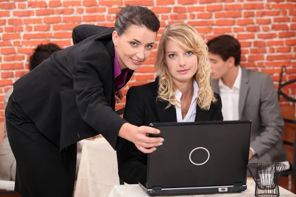 Jonge vrouwen met behulp van een laptop in een restaurant — Stockfoto