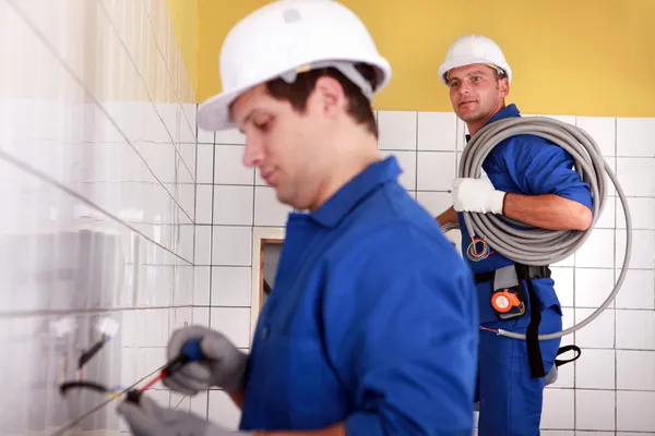 Elektrikáři instalatéři v koupelně — Stock fotografie