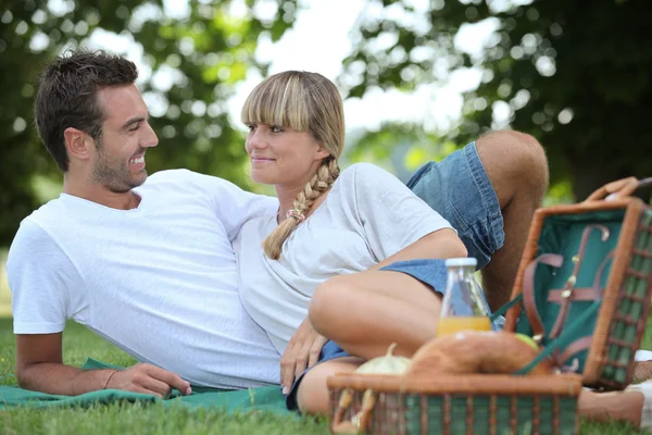 Jeune couple ayant un pique-nique dans le parc — Photo