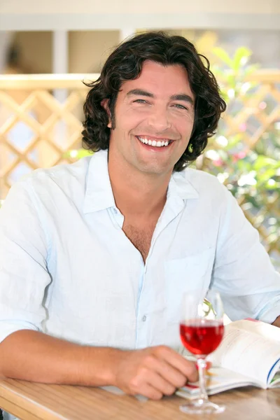 Χαμογελαστός άνθρωπος απολαμβάνοντας ένα ποτήρι ροζέ — Φωτογραφία Αρχείου