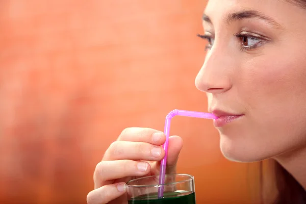 Woman drinking green drink — Stock Photo, Image