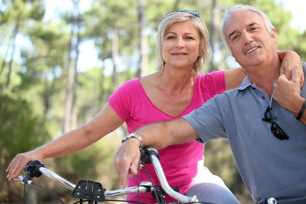 Porträtt av äldre par på cykel — Stockfoto