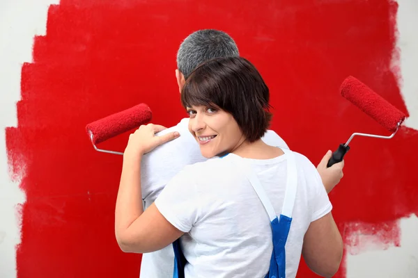 Um homem e sua esposa pintando uma parede — Fotografia de Stock