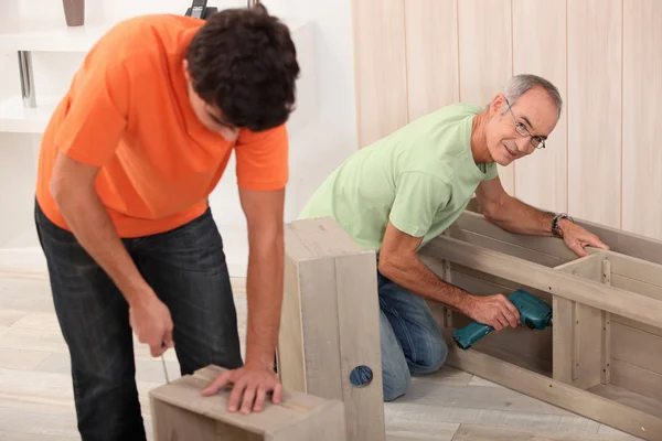 Far och son att sätta ihop flat pack möbler — Stockfoto