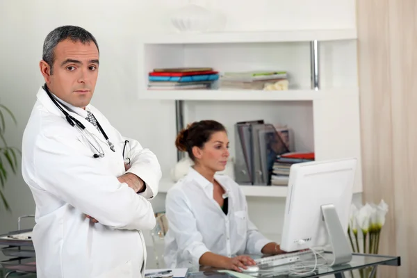Doutor com sua secretária — Fotografia de Stock