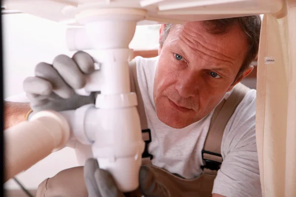 Mann repariert Waschbecken für Kunden — Stockfoto
