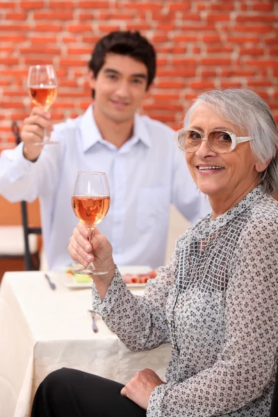 Mormor och ung man dricka rose vin — Stockfoto