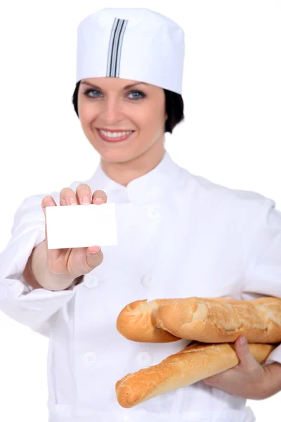 Vendedora na padaria segurando cartão de visita — Fotografia de Stock