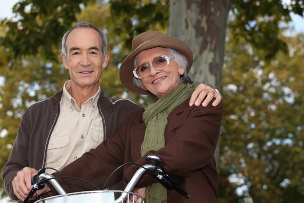 森の中高齢者のカップル、自転車に乗る — ストック写真