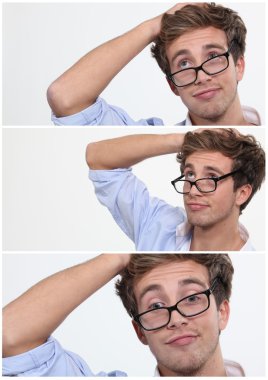 Young man with his glasses askew and hand to his head clipart