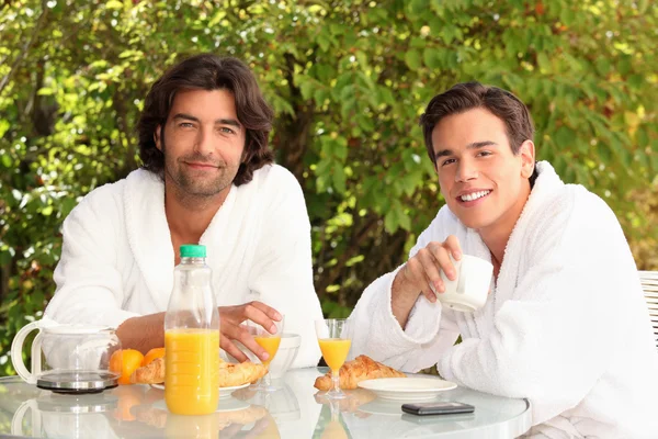 45 years old man and a 20 years old man dressed in bathrobe drinking coffee — Stock Photo, Image