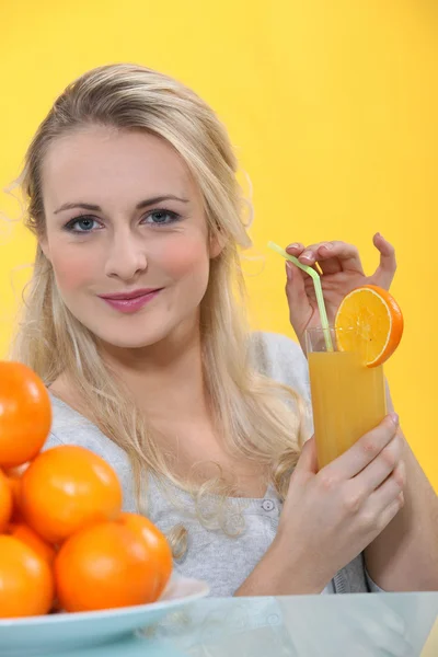 Γυναίκα με ένα ποτήρι χυμό πορτοκάλι — Φωτογραφία Αρχείου