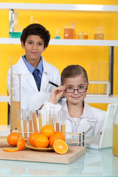 Niños haciendo experimentos químicos con zumo de naranja — Foto de Stock