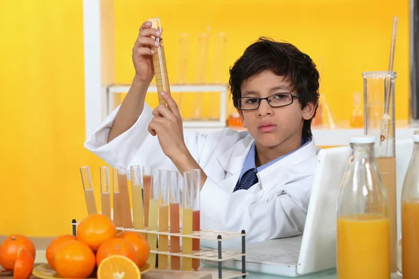 小孩玩着一套化学仪器和橘子 — 图库照片