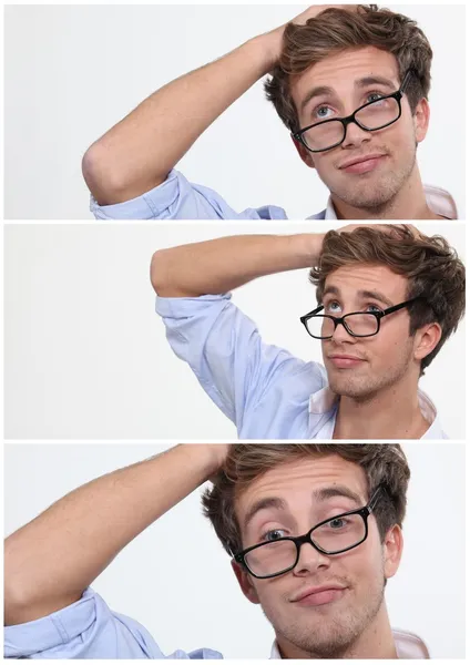 Fiatalember, felhúzott szemüveggel, kezekkel a fejéhez. — Stock Fotó