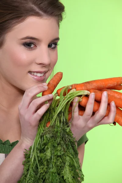 Retrato de una chica guapa posando con zanahorias — Foto de Stock