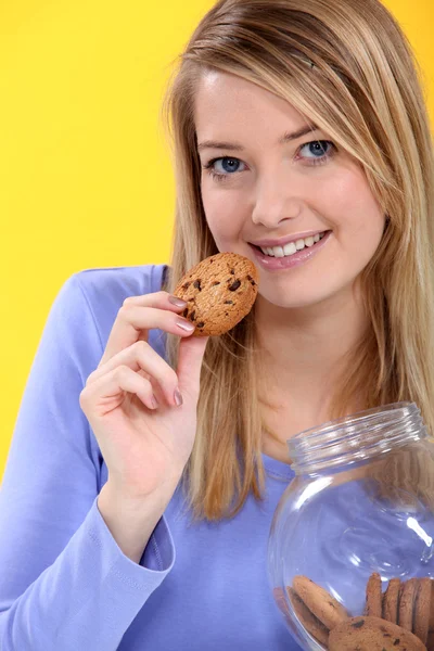 Mulher comendo um biscoito — Fotografia de Stock