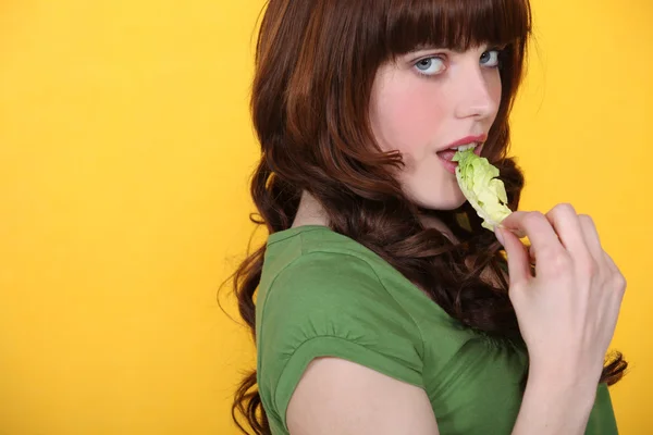 Mulher comendo folha de alface verde — Fotografia de Stock