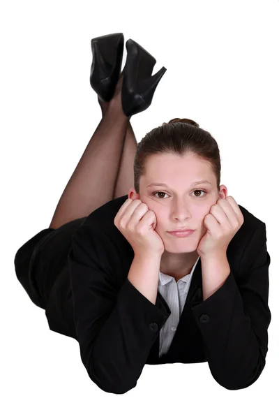 Vrouw in een pak liggen en op zoek naar ernstige — Stockfoto