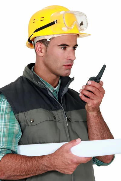 Foreman with blueprints holding talkie walkie — Stock Photo, Image