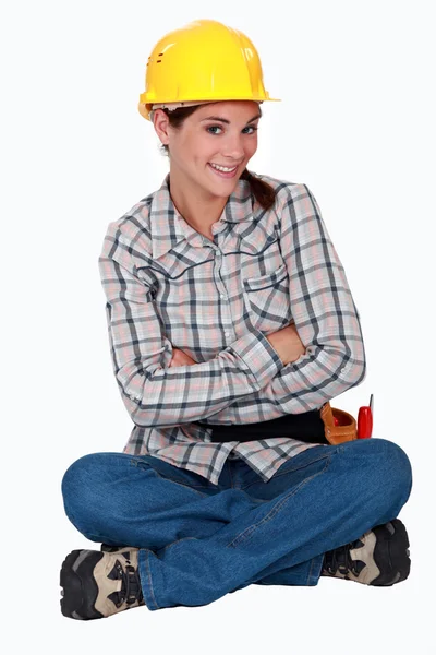 A cute female construction worker sitting on the floor. — Stock Photo, Image