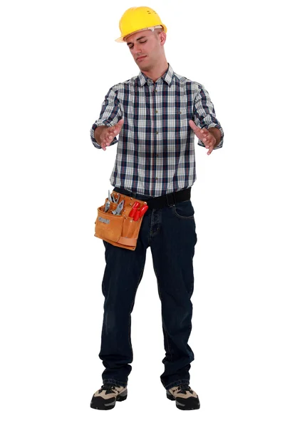 Tradesman holding an invisible object — Stock Photo, Image