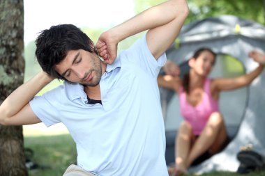 Camping couple waking up in the morning clipart