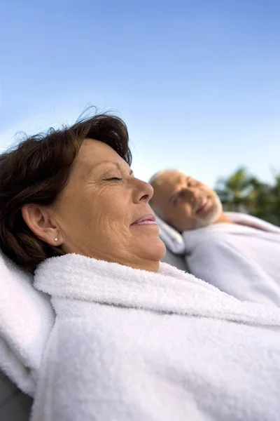 Couple laying in dressing gowns — Stock Photo, Image