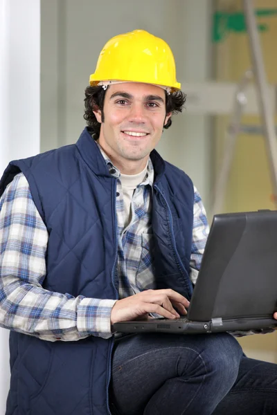Builder satt med laptop — Stockfoto