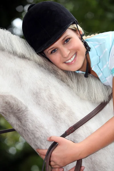 Blond meisje paardrijden paard — Stockfoto