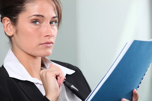 Serious young businesswoman making notes — Stock Photo, Image